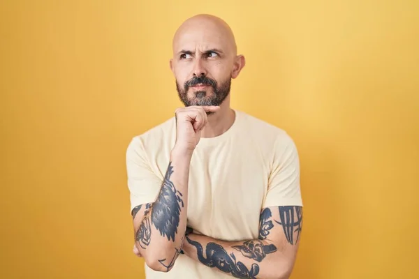 Homem Hispânico Com Tatuagens Sobre Fundo Amarelo Com Mão Queixo — Fotografia de Stock