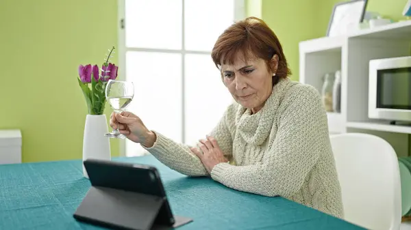 Ältere Hispanische Frau Sieht Video Auf Touchpad Auf Tisch Sitzend — Stockfoto