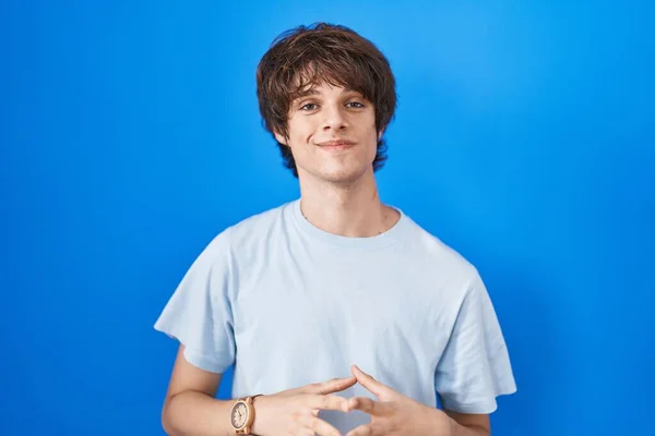 Hispanic Young Man Standing Blue Background Hands Together Fingers Crossed — 图库照片