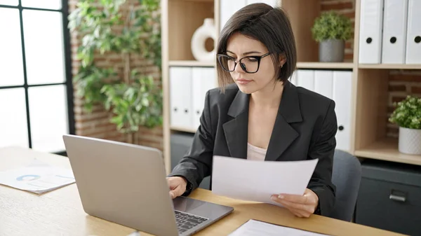 オフィスでノートパソコン読み取り文書を使用して若い白人女性のビジネスワーカー — ストック写真