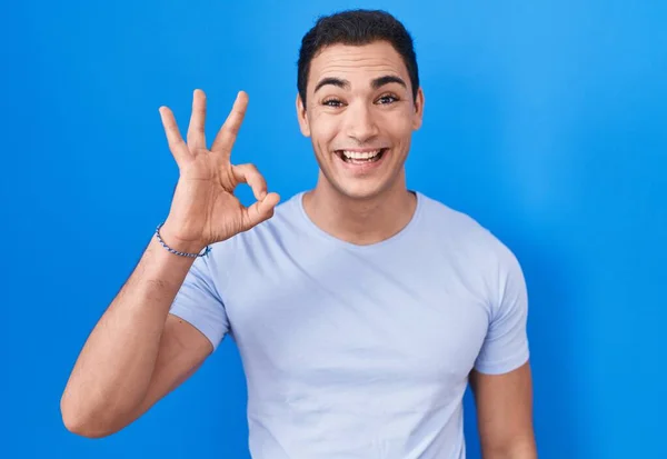 Mladý Hispánec Stojící Nad Modrým Pozadím Usmívající Pozitivně Dělá Pořádku — Stock fotografie