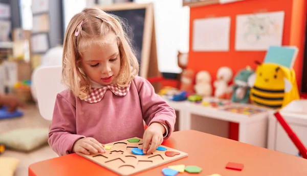 可爱的金发女孩在幼儿园玩数学拼图游戏 — 图库照片