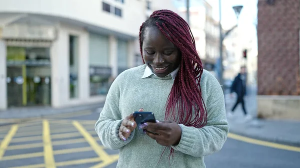 在街上用智能手机剪辫子的非洲妇女 — 图库照片