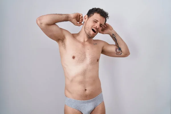 Ung Latinamerikansk Man Står Tröjlös Klädd Underkläder Sträcker Sig Tillbaka — Stockfoto