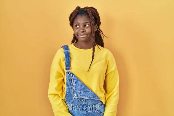Mujer Africana Pie Sobre Fondo Amarillo Sonriendo Mirando Hacia Lado —  Fotos de Stock