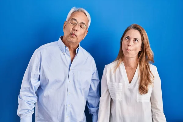 Couple Hispanique Moyen Age Debout Sur Fond Bleu Faisant Face — Photo