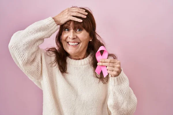 中年パニック女性保持ピンク癌リボン強調し フラストレーションとともに手頭 驚きと怒っている顔 — ストック写真