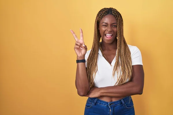 Африканская Американка Плетеными Волосами Стоит Жёлтом Фоне Улыбается Счастливым Лицом — стоковое фото