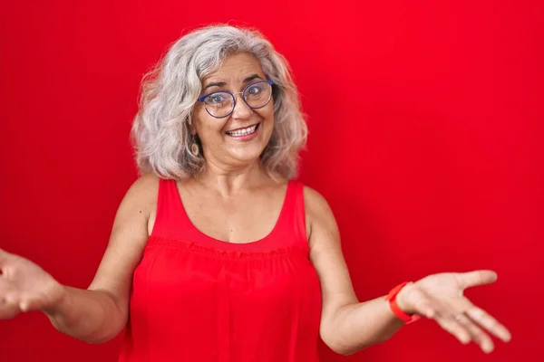 Kırmızı Arka Planda Gri Saçlı Orta Yaşlı Bir Kadın Gülümseyerek — Stok fotoğraf