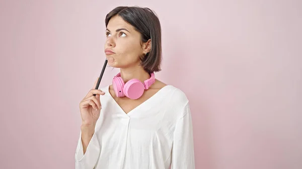 Junge Schöne Hispanische Frau Mit Kopfhörern Denkt Über Isolierten Rosa — Stockfoto