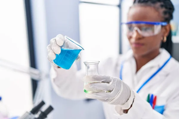 アフリカ系アメリカ人女性科学者は自信を持って液体を注ぐ笑みを浮かべて実験室でチューブ — ストック写真