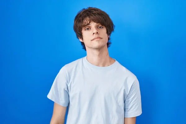 Hispanic Young Man Standing Blue Background Relaxed Serious Expression Face — 图库照片