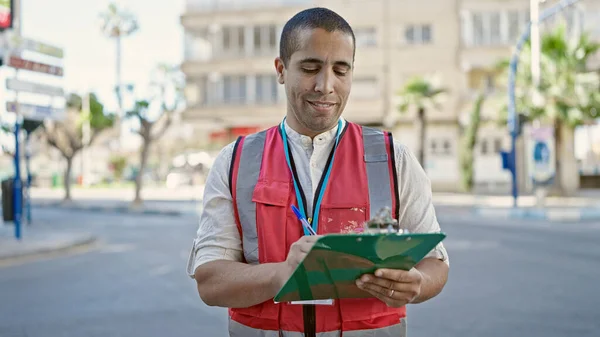 若いですヒスパニック系の男ボランティア笑顔保持クリップボードでストリート — ストック写真