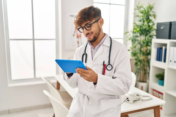 Young Arab Man Wearing Doctor Uniform Using Touchpad Working Clinic — Stock Photo, Image