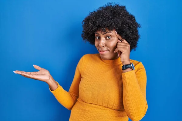Zwarte Vrouw Met Krullend Haar Staan Blauwe Achtergrond Verward Geïrriteerd — Stockfoto