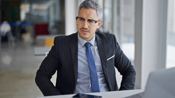 若いヒスパニック系男性ビジネスワーカーがオフィスでラップトップを使用してメガネを着用 — ストック写真