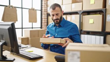 Latin kökenli genç bir iş adamı ofisteki hatırlatma kağıdına bilgisayar yazısını kullanıyor.