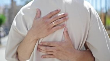 Sokakta birbirine sarılan iki erkek.