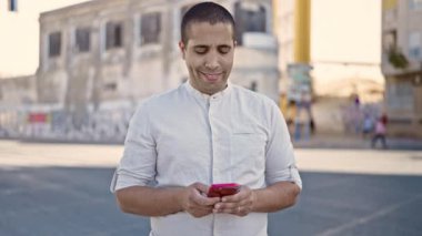 Sokakta akıllı telefon kullanan genç bir İspanyol.