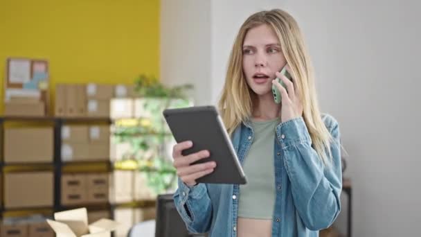 若いブロンドの女性は オフィスでスマートフォンで話してタッチパッドを使用してビジネスワーカーをEコマース — ストック動画
