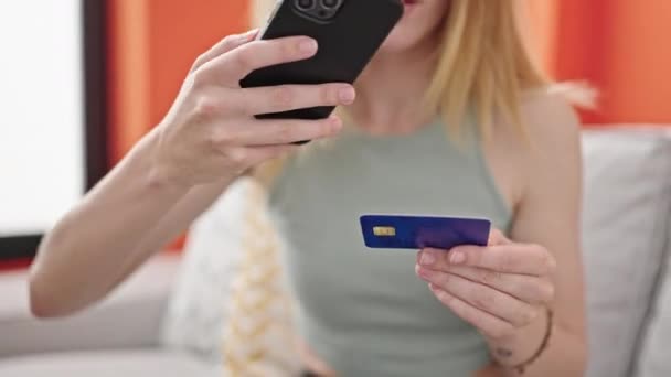 Ung Blond Kvinna Gör Foto Till Kreditkort Smartphone Sitter Soffan — Stockvideo