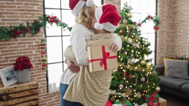 Man and woman couple hugging each other celebrating christmas at home