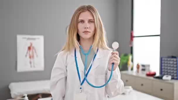Jeune Femme Blonde Médecin Souriant Confiant Tenant Stéthoscope Clinique — Video