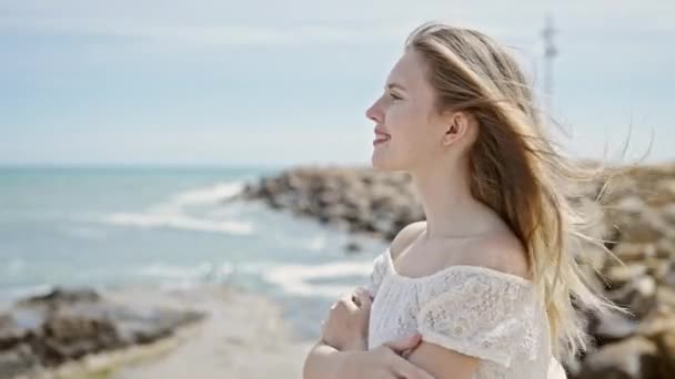 Młoda Blondynka Turystka Uśmiecha Się Pewnie Przytulając Się Plaży — Wideo stockowe