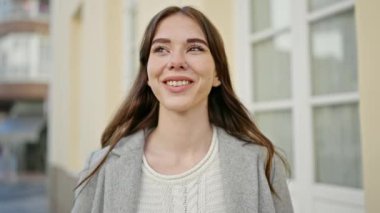 Sokakta kendinden emin gülümseyen genç İspanyol kadın.
