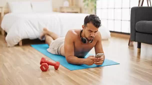 Hombre Hispano Joven Usando Smartphone Acostado Colchoneta Yoga Dormitorio — Vídeos de Stock
