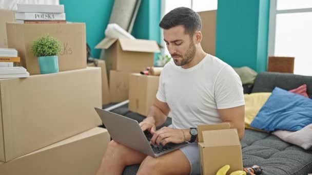 Young Hispanic Man Using Laptop Sitting Sofa New Home — Stockvideo