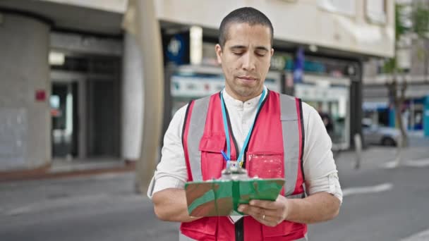 Young Hispanic Man Volunteer Smiling Writing Clipboard Street — Stock Video