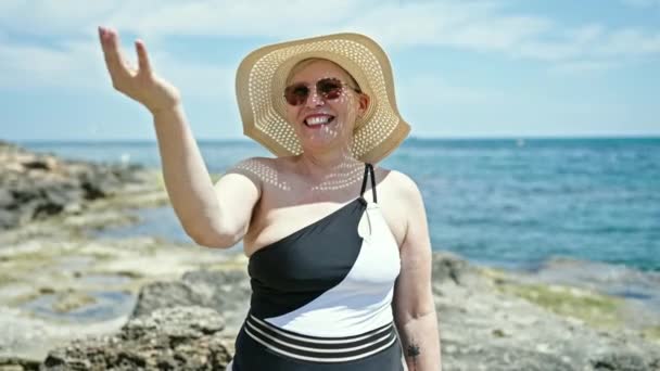 수영복을 모자를 중년의 관광객 해변에서 제스처를 있습니다 — 비디오