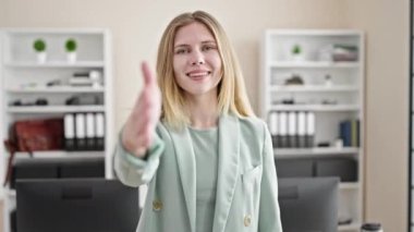 Young blonde woman business worker smiling confident shake hand at office