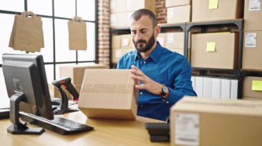 Genç İspanyol adam ecommerce iş adamı ofiste tarama paketi