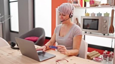 Yemek salonunda kredi kartı tutan genç bir kadın.