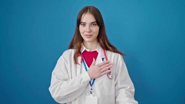 Young Hispanic Woman Doctor Making Oath Hand Chest Isolated Blue — Stock Video