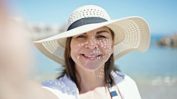 中年时 他惊慌失措的女游客戴着夏帽 在海滩上自拍 面带微笑 — 图库视频影像
