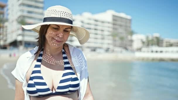 中年时 他惊慌失措的女游客笑着在海滩上拿着夏帽 — 图库视频影像