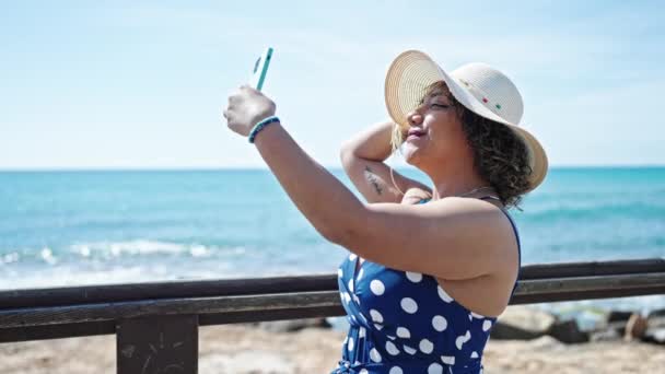 年轻美丽的拉汀女游客头戴夏帽 在海滨用智能手机自拍 — 图库视频影像