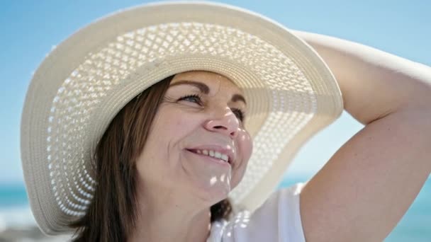 中年时 他惊慌失措的女游客笑着在海滩上拿着夏帽 — 图库视频影像