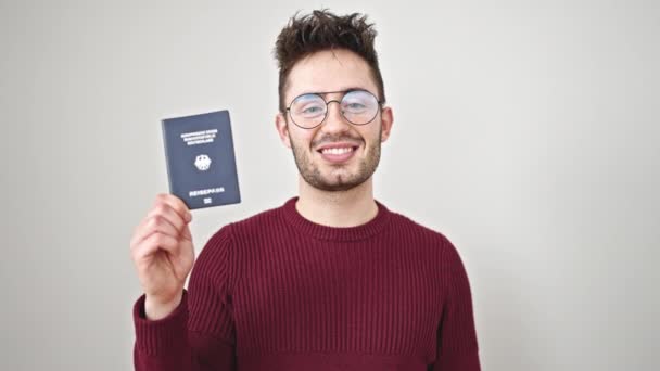 年轻的他惊慌失措的男人微笑着 自信地拿着杜什兰护照 披着孤零零的白底 — 图库视频影像