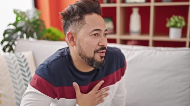Junger Lateinischer Mann Lächelt Selbstbewusst Auf Sofa Und Spricht Hause — Stockvideo