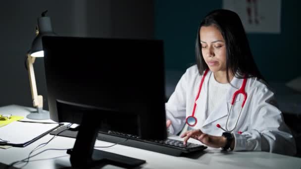 Νεαρή Όμορφη Ισπανόφωνη Γυναίκα Γιατρός Χρησιμοποιώντας Υπολογιστή Κοιτάζοντας Ρολόι Στην — Αρχείο Βίντεο
