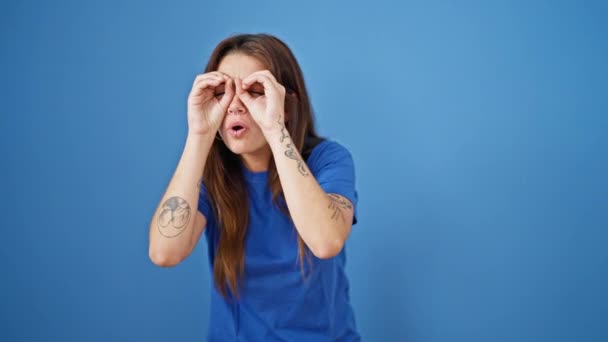 Young Beautiful Hispanic Woman Doing Binoculars Gesture Hands Looking Isolated — Stock Video