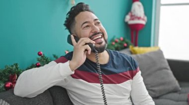 Genç Latin adam telefonda Noel 'i evde kutluyor.