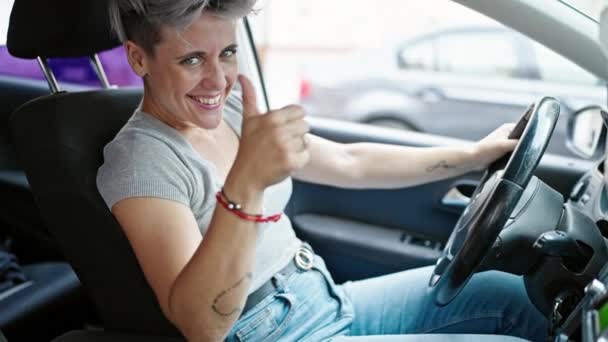 ストリートで親指でジェスチャーをしている車を運転する若い女性 — ストック動画