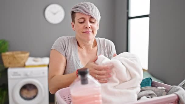 Jonge Vrouw Ruikt Schone Handdoek Met Fles Wasmiddel Wasruimte — Stockvideo
