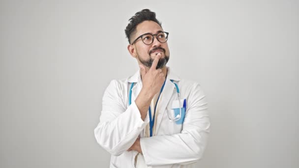 Junger Lateinischer Arzt Steht Mit Zweifelndem Gesichtsausdruck Vor Isoliertem Weißem — Stockvideo