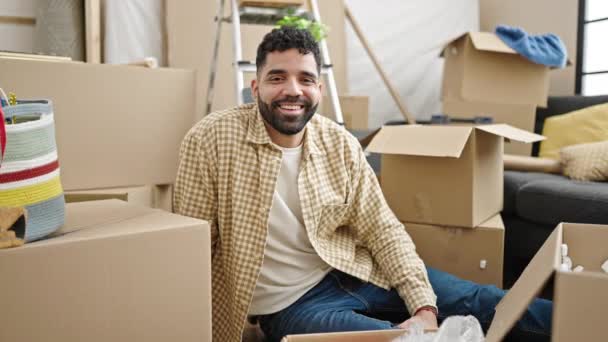 Young Hispanic Man Smiling Confident Sitting Floor New Home — Stockvideo